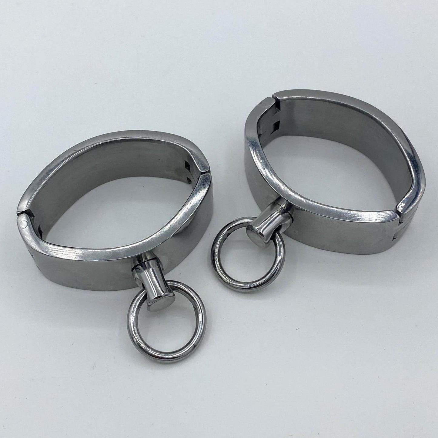 Wide stainless steel cuffs with rings. Ø: 6,5cm x 4,5cm
