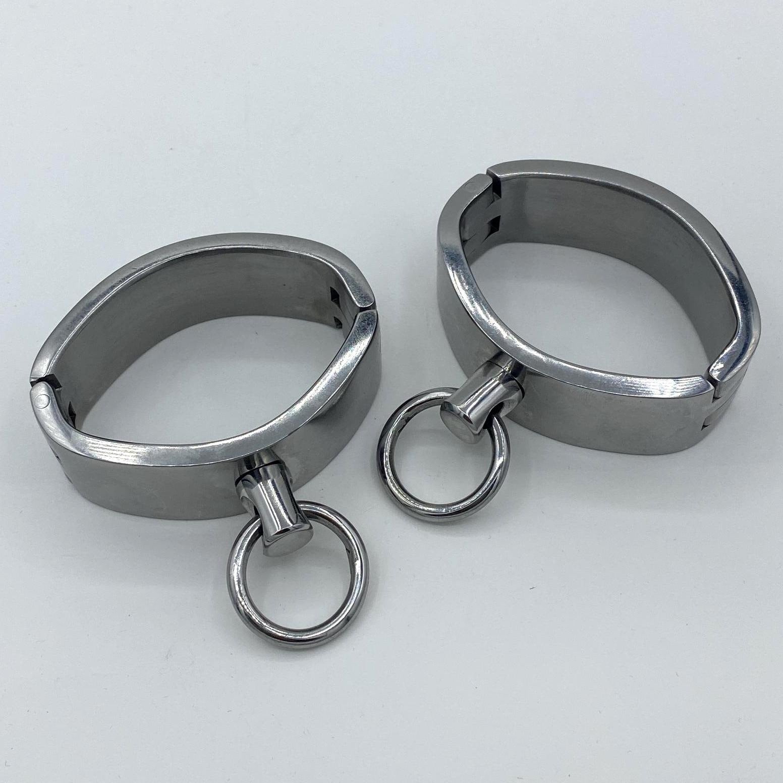 Wide stainless steel cuffs with rings. Ø: 6,5cm x 4,5cm