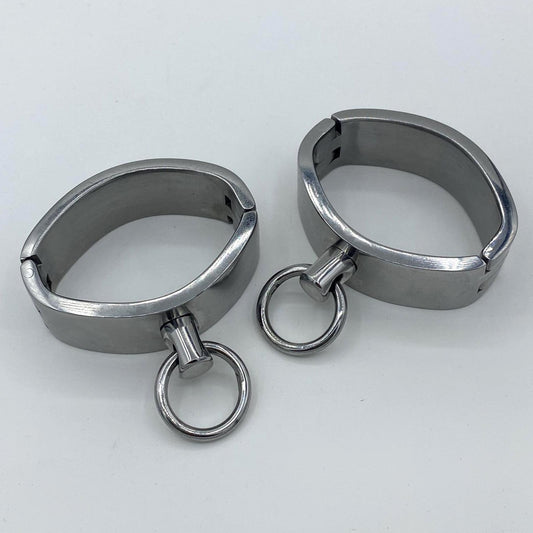 Wide stainless steel cuffs with rings. Ø: 6,5cm x 4,5cm